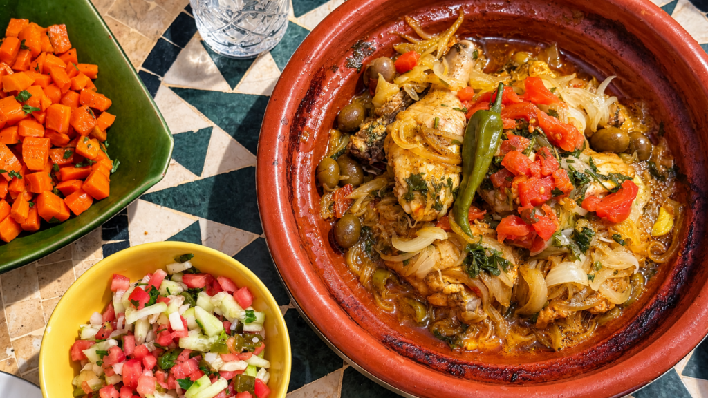 Déjeuner traditionnel marocain avec tajine de poulet, légumes et salade lors d’une excursion dans le Souss-Massa.